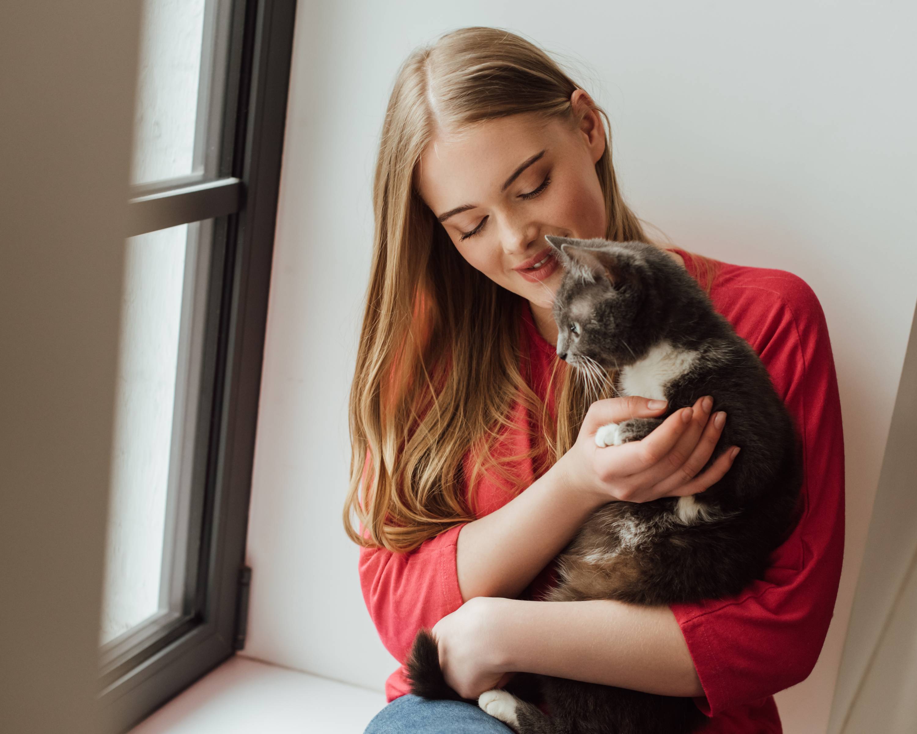 Frau mit Katze am Fenster